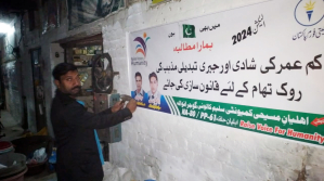 Activist in Pakistan putting up a banner