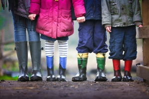 children standing in rain boots