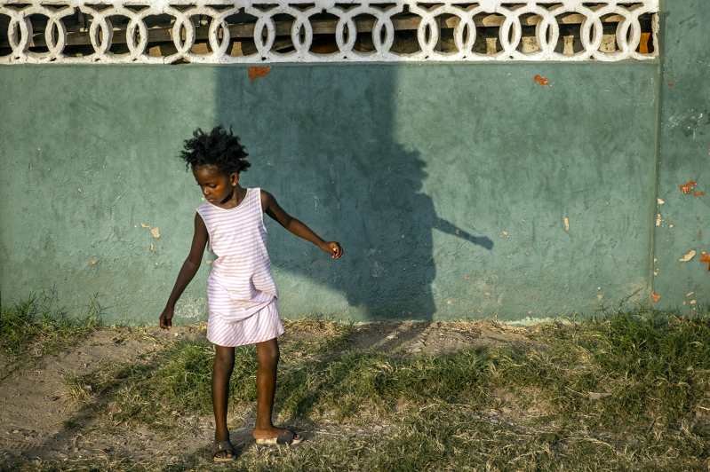 A young girl plays in a small patch of grass in the old Jamestown quarter of Accra, Ghana