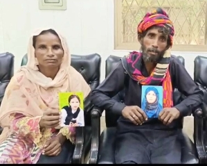 Sumera Bibi and her husband with portraits of their forcibly converted and married daughters who were kidnapped in Kasur District, Pakistan on July 23, 2024. 