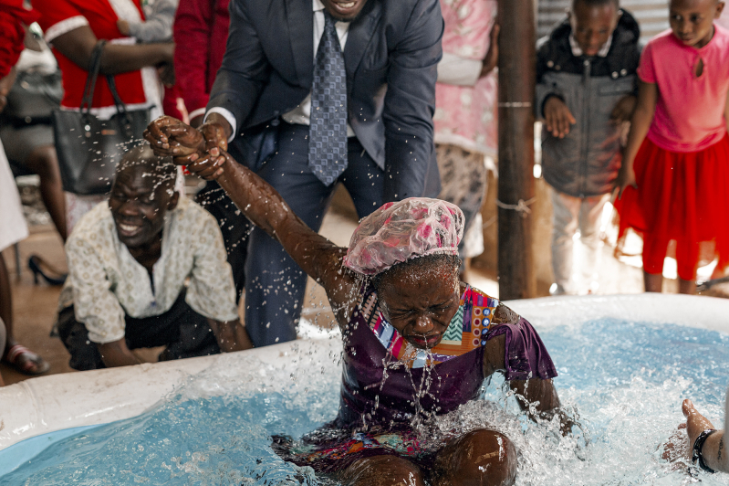 A woman is baptized in a church in Kenya