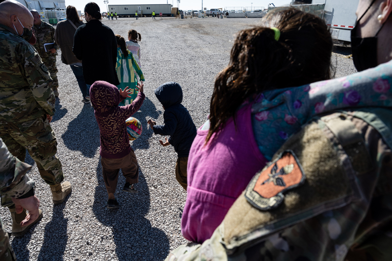 Children play with a ball as they walk with a group of media and military service members in an Afghan refugee camp on November 4, 2021 in Holloman Air Force Base, New Mexico.